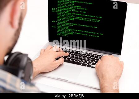 Man using laptop, writing programming code on laptop Stock Photo