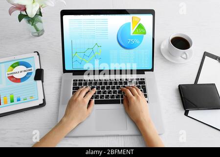 Woman working with modern laptop, with scheme on screen Stock Photo