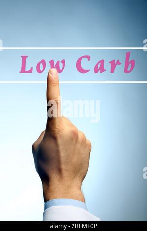 Doctor pointing on Low-Carb text on blue background Stock Photo