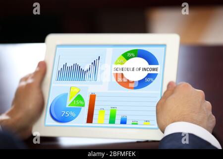 Businessman holding tablet-pc with scheme on screen Stock Photo
