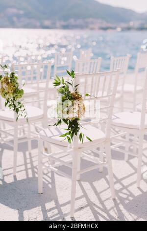 white wedding chairs outdoors venue. Wedding venue outdoors with sea view. Stock Photo