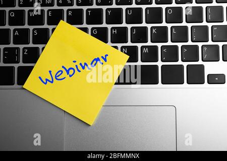 Webinar written on sticky note on laptop keyboard Stock Photo