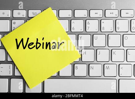 Webinar written on sticky note on laptop keyboard Stock Photo