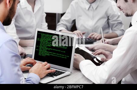 Man using laptop, writing programming code on laptop Stock Photo