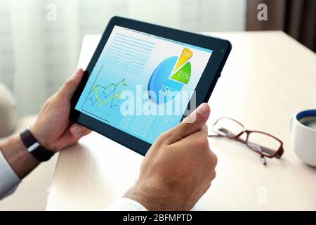 Businessman holding tablet-pc with scheme on screen Stock Photo