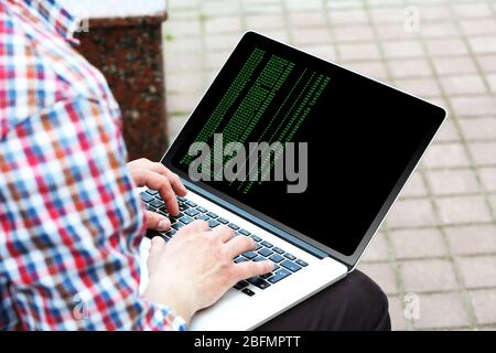 Man using laptop, writing programming code on laptop Stock Photo