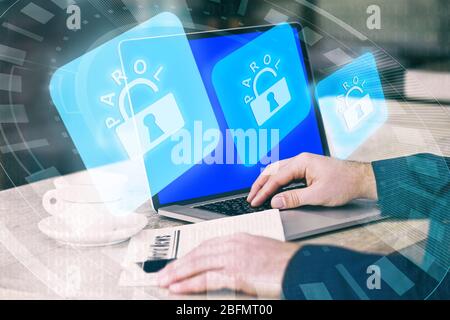 Man working on laptop with icons security on virtual display. Technology, internet and networking concept. Stock Photo