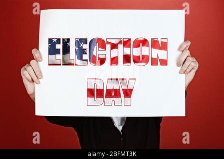Woman holding paper with Election Day text on red background Stock Photo