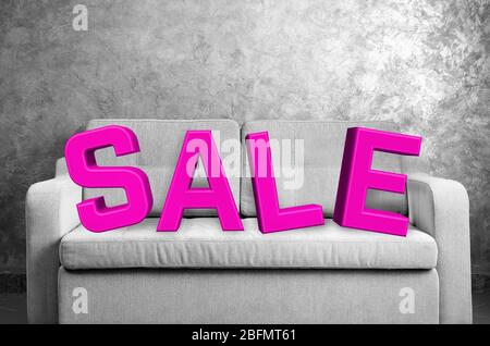 Sale concept. Comfortable sofa against grey wall in the room Stock Photo
