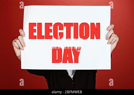 Hands holding card with Election Day text on red background Stock Photo