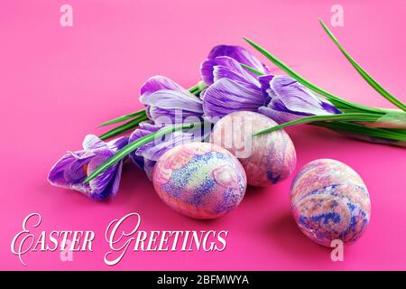 Easter greeting card. Multicoloured eggs and crocuses on pink background Stock Photo