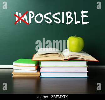 Word impossible transformed into possible on blackboard and textbooks Stock Photo
