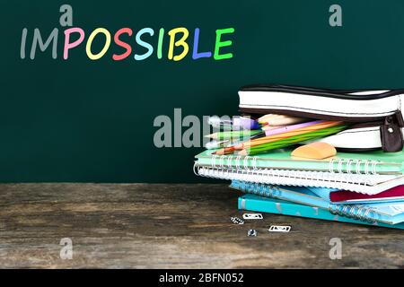 Word impossible transformed into possible on blackboard and textbooks Stock Photo