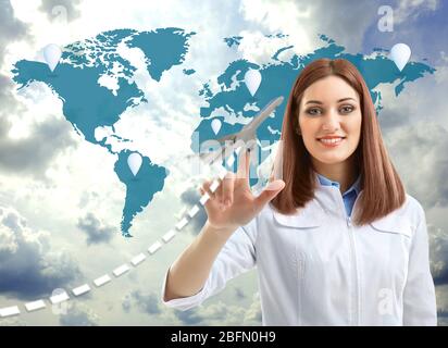 Doctor touching plane icon on virtual screen. Medical tourism concept Stock Photo