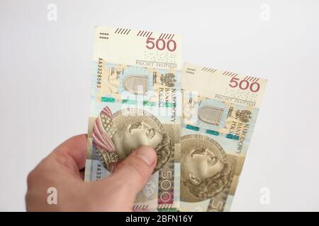 close up of two banknotes with a face value of PLN 500 Polish money, zloty held  in the hands  on a white background Stock Photo