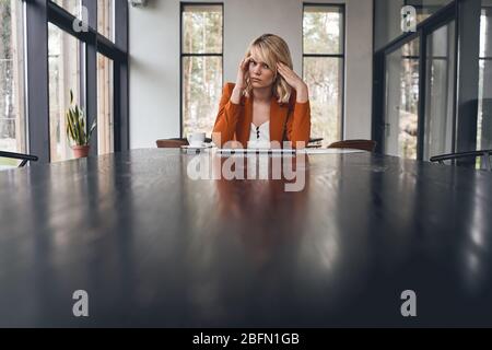 Low-spirited blonde female suffering from a headache Stock Photo