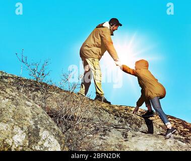 Helping hands with sunlight between two climbers Stock Photo
