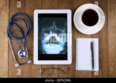 X-ray on tablet screen and stethoscope on wooden background Stock Photo