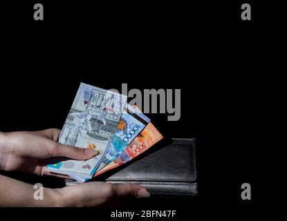 Hold wallet with money in hand. Tenge KZT. National currency of Kazakhstan, KZ. Exchange rate. Economy, development, business, Bank, broker. Stock Photo
