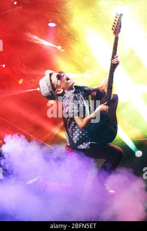 Little boy playing guitar on a bright background Stock Photo