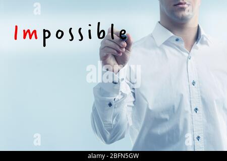 Human hand turning word impossible into possible Stock Photo