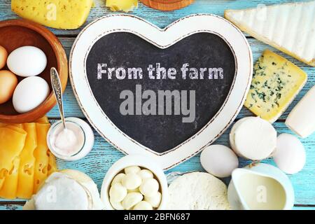 Text From the farm in frame of fresh dairy products on blue wooden table Stock Photo