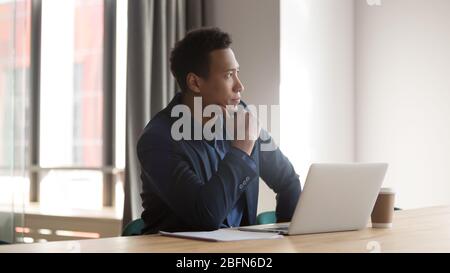 Mixed race entrepreneur sit at desk looking out the window Stock Photo