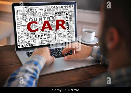 Young man using his laptop, close up. Car word collage Stock Photo