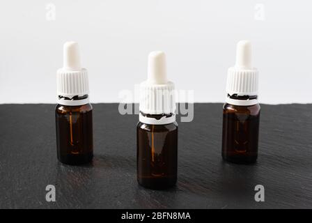 cosmetic concept, three glass bottles with serum on a black and white background Stock Photo