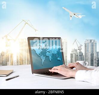 Female hands working with laptop, worldwide network on screen. Cityscape background. Transport logistic concept. Stock Photo