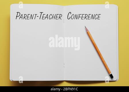 Text PARENT-TEACHER CONFERENCE written in notebook. Yellow background. School concept. Stock Photo