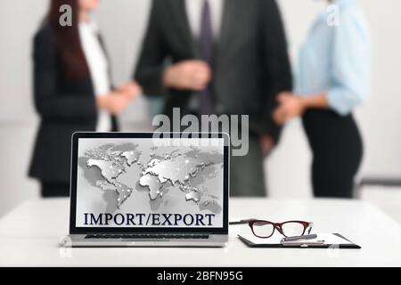 Text IMPORT/EXPORT and world map on laptop screen. Business concept. Stock Photo