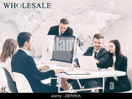 People working at modern office. Word WHOLESALE and world map on background. Business concept. Stock Photo