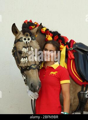 Female groom lead andalusian horse at rural stables Stock Photo