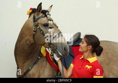 Female groom lead andalusian horse at rural stables Stock Photo