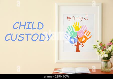 Painting with family palms prints on wall. Text CHILD CUSTODY on wall background Stock Photo