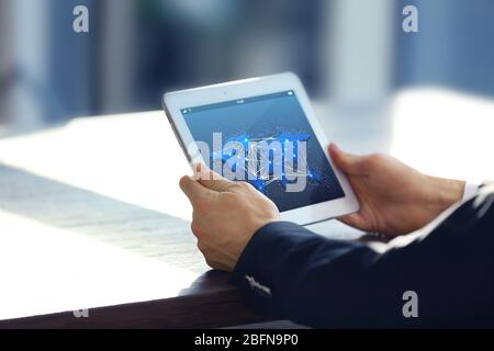 Male hands with tablet, closeup. World map with delivery network on screen. Logistics concept. Stock Photo