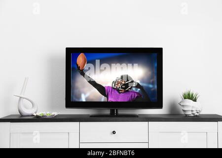Watching American football game on television at home. Leisure and entertainment concept. Stock Photo