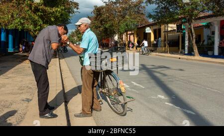 Local Cubans - man giving someone a light for a cigar, Viñales, Cuba Stock Photo