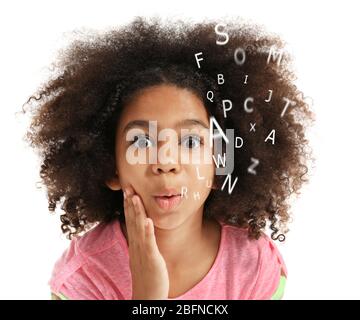 African-American little girl with book and alphabet letters on white background. Speech therapy concept Stock Photo