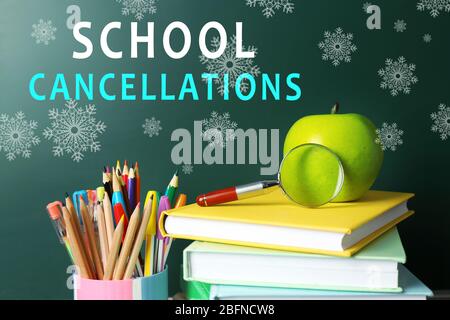 Books and stationery on chalkboard background with text SCHOOL CANCELLATIONS Stock Photo