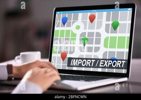 Logistics concept. Man with laptop, closeup. Text IMPORT/EXPORT and map on screen Stock Photo