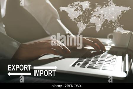 Logistics concept. Man with laptop, closeup. Text EXPORT-IMPORT on background Stock Photo