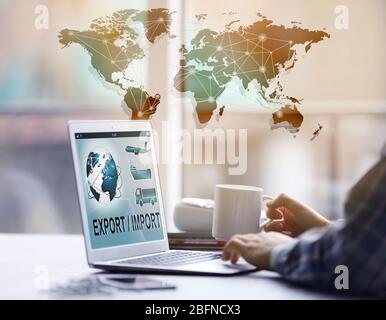 Logistics concept. Man with laptop. Text EXPORT/IMPORT on screen Stock Photo