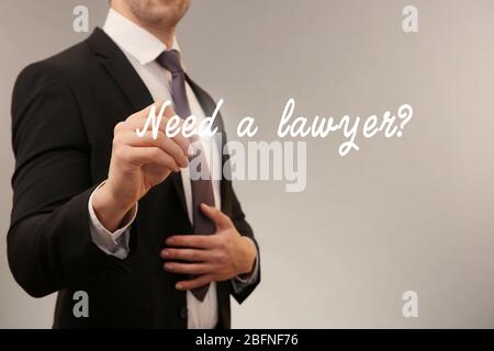 Man writing text NEED A LAWYER? on virtual screen Stock Photo