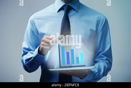 Online banking concept. Man using tablet and magnifier Stock Photo