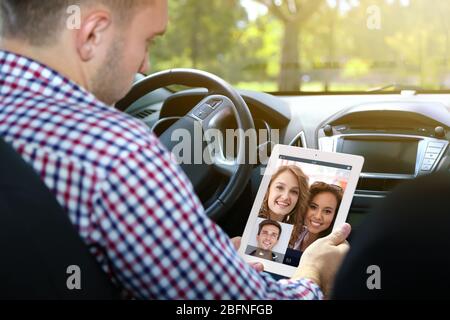 Man video conferencing on tablet in car.  Modern technology concept. Stock Photo