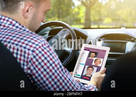 Man video conferencing on tablet in car.  Modern technology concept. Stock Photo