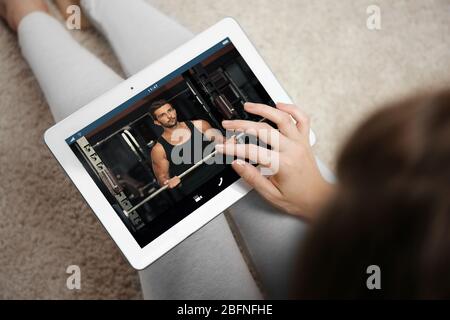 Woman watching sport training online on tablet. Fitness and sport blog. Stock Photo