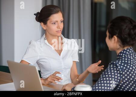 Diverse female office workers working on project sitting at workplace Stock Photo